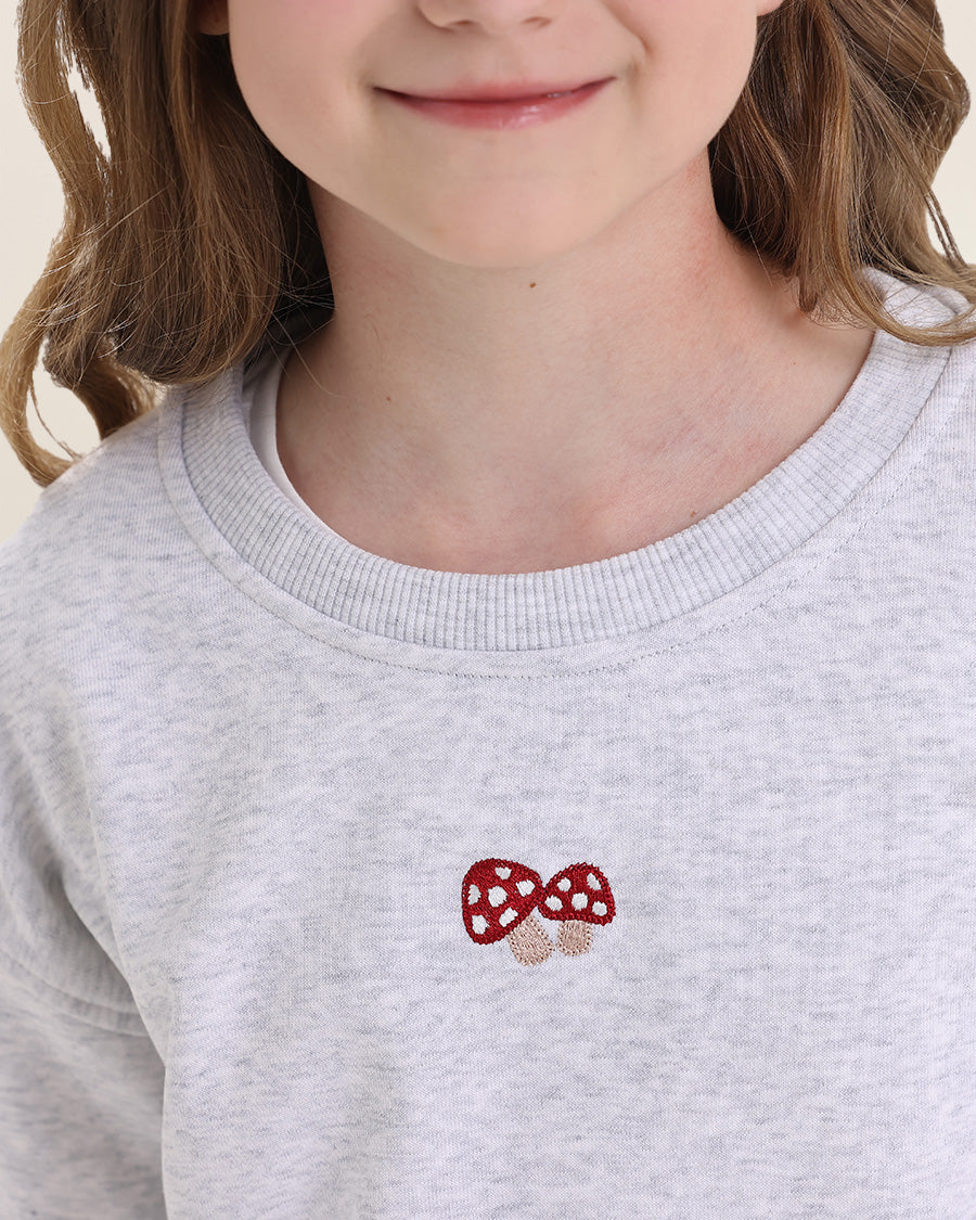 Gray sweatshirt with red and white mushroom design worn by a child