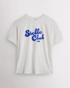 White Stelle oversized T-shirt with a blue Stelle Club graphic, laid flat on a grey background.