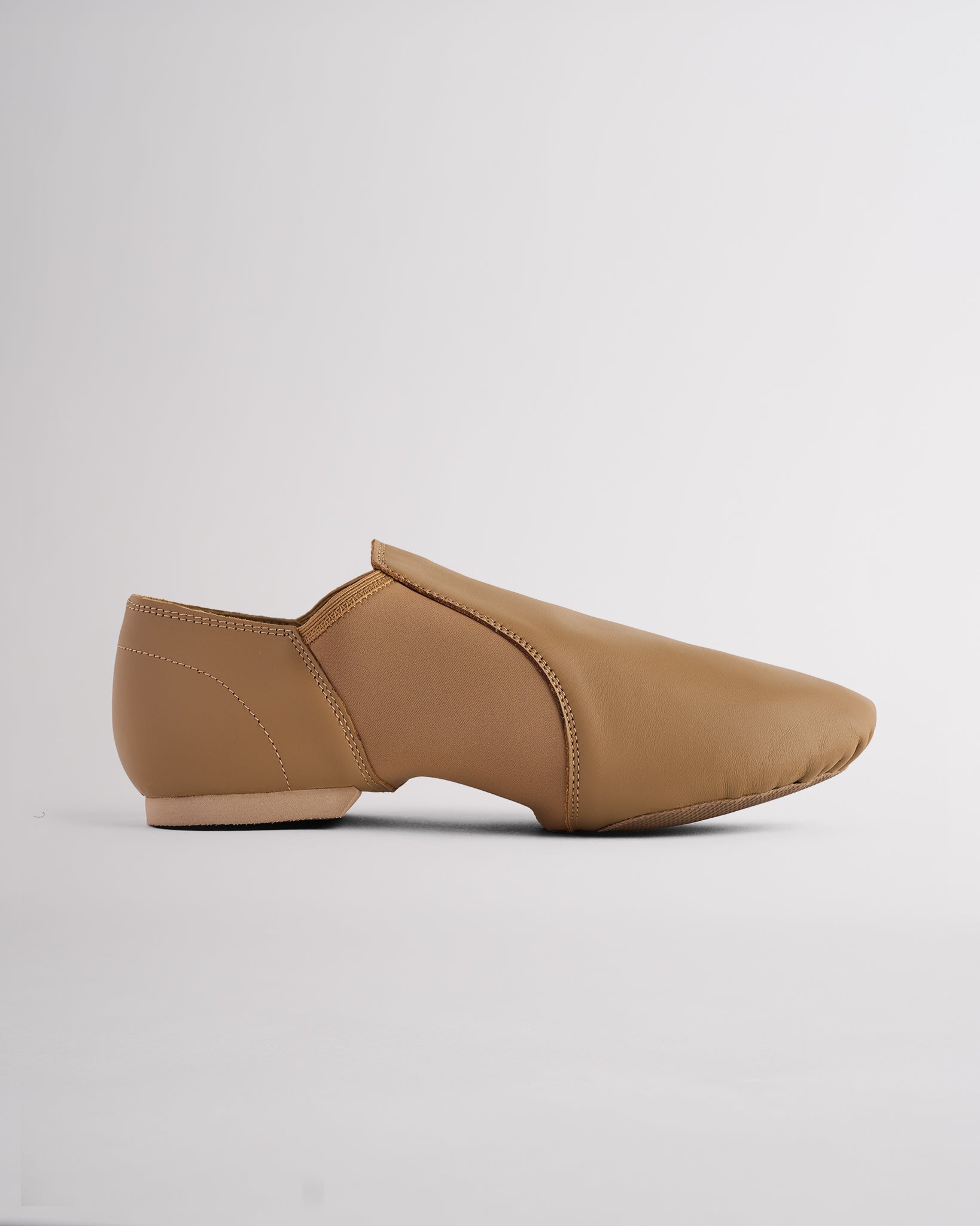 Latte slip-on jazz shoe with split-sole design, stretchy neoprene arch, and sleek second-skin fit for jazz and dance.