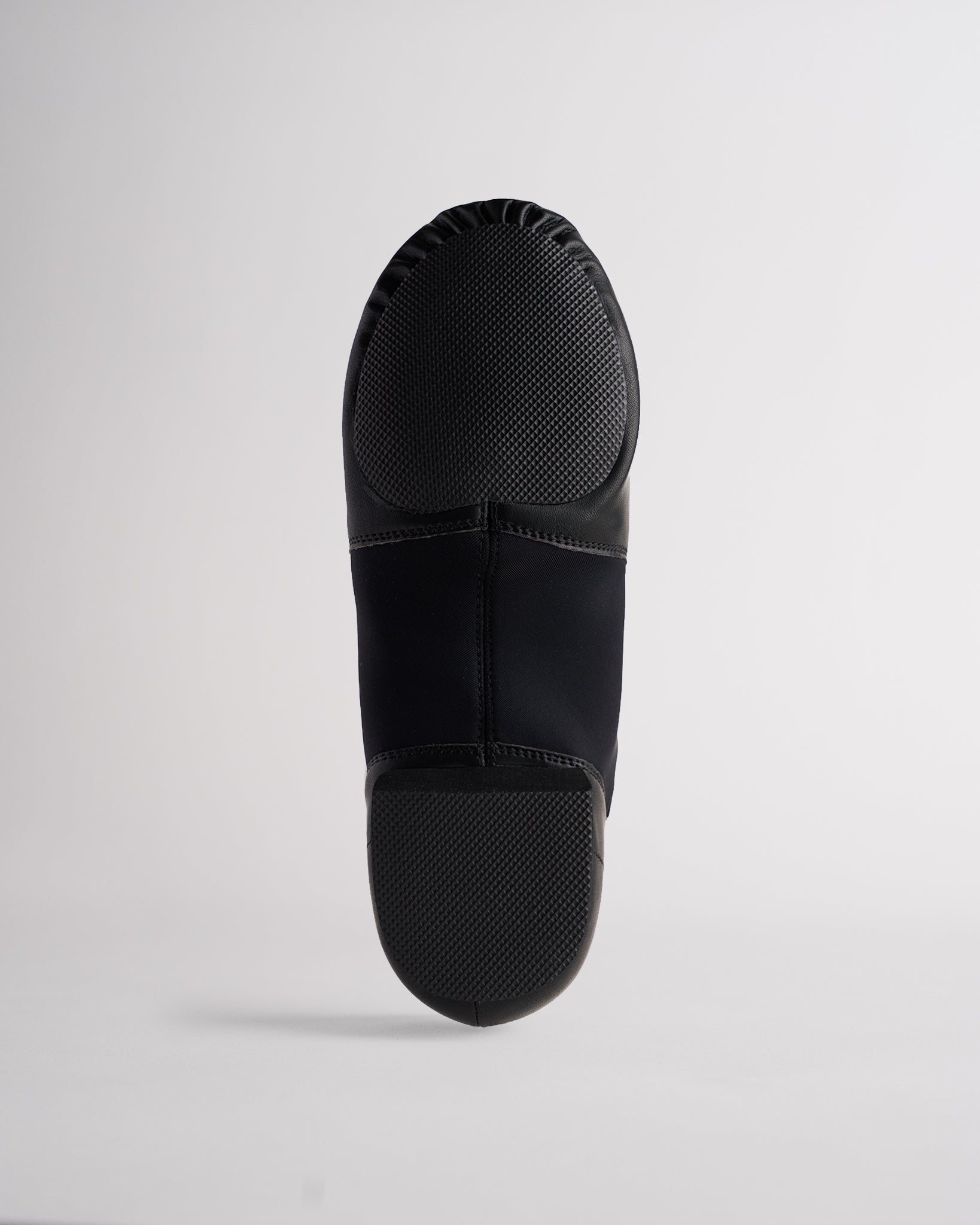 Sole view of black adult jazz shoe showing anti-slip split sole and textured grip panels.