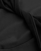 Close-up of Black performance leotard showing soft stretch fabric and twisted mesh back detail.
