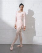 Dancer wearing a ballet pink mesh dance skirt with adjustable side ruching over a matching ballet outfit.