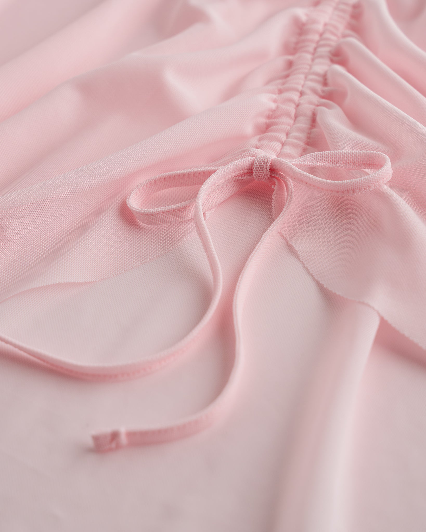 Close-up of ballet pink mesh ballet skirt showing adjustable ruched drawstring and soft sheer fabric.