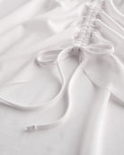 Close-up of white mesh ballet skirt showing adjustable ruched drawstring and soft sheer fabric.