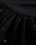 Close-up of black tutu dress skirt showing multicolor celestial sequins, layered mesh, and star and moon details.