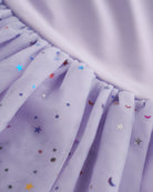 Close-up of lavender tutu dress skirt showing multicolor celestial sequins, layered mesh, and star and moon details.