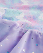 Close-up of Magic Flutter sequin dress fabric showing shimmer details, printed bodice, and layered chiffon skirt.