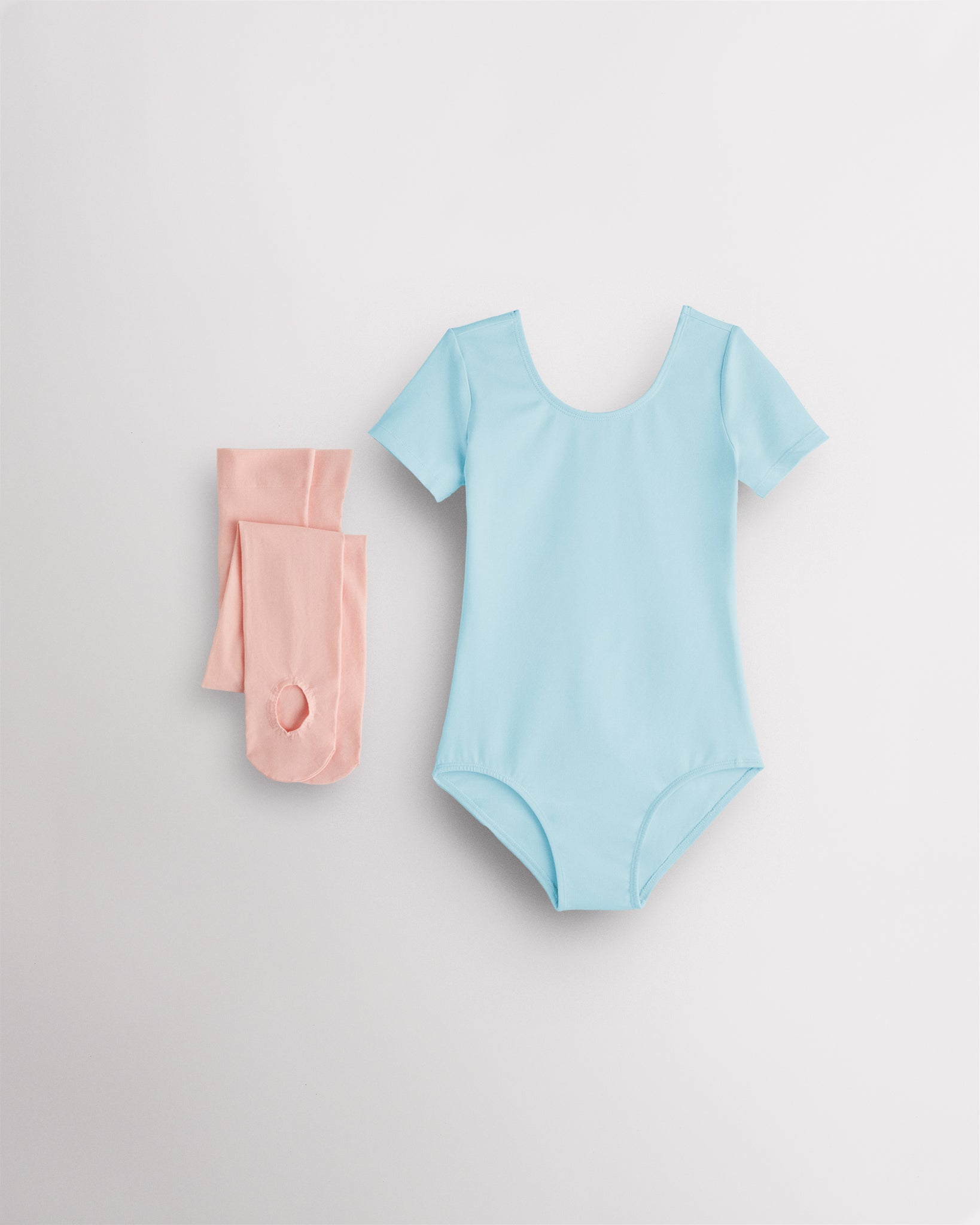 Blue short sleeve leotard with pink convertible dance tights laid flat for girls ballet and dance class.