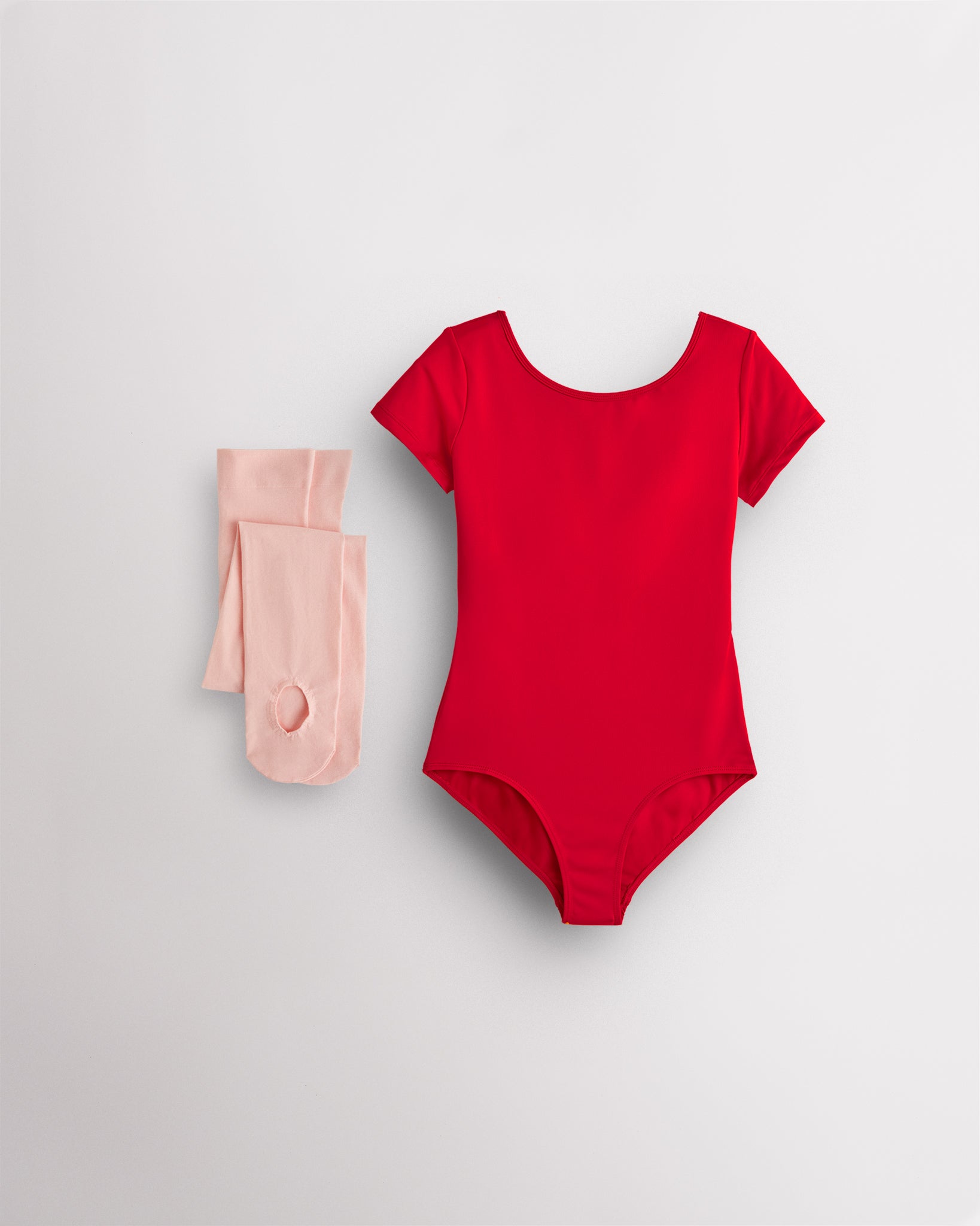 Red short sleeve leotard with pink convertible dance tights laid flat for girls ballet and dance class.
