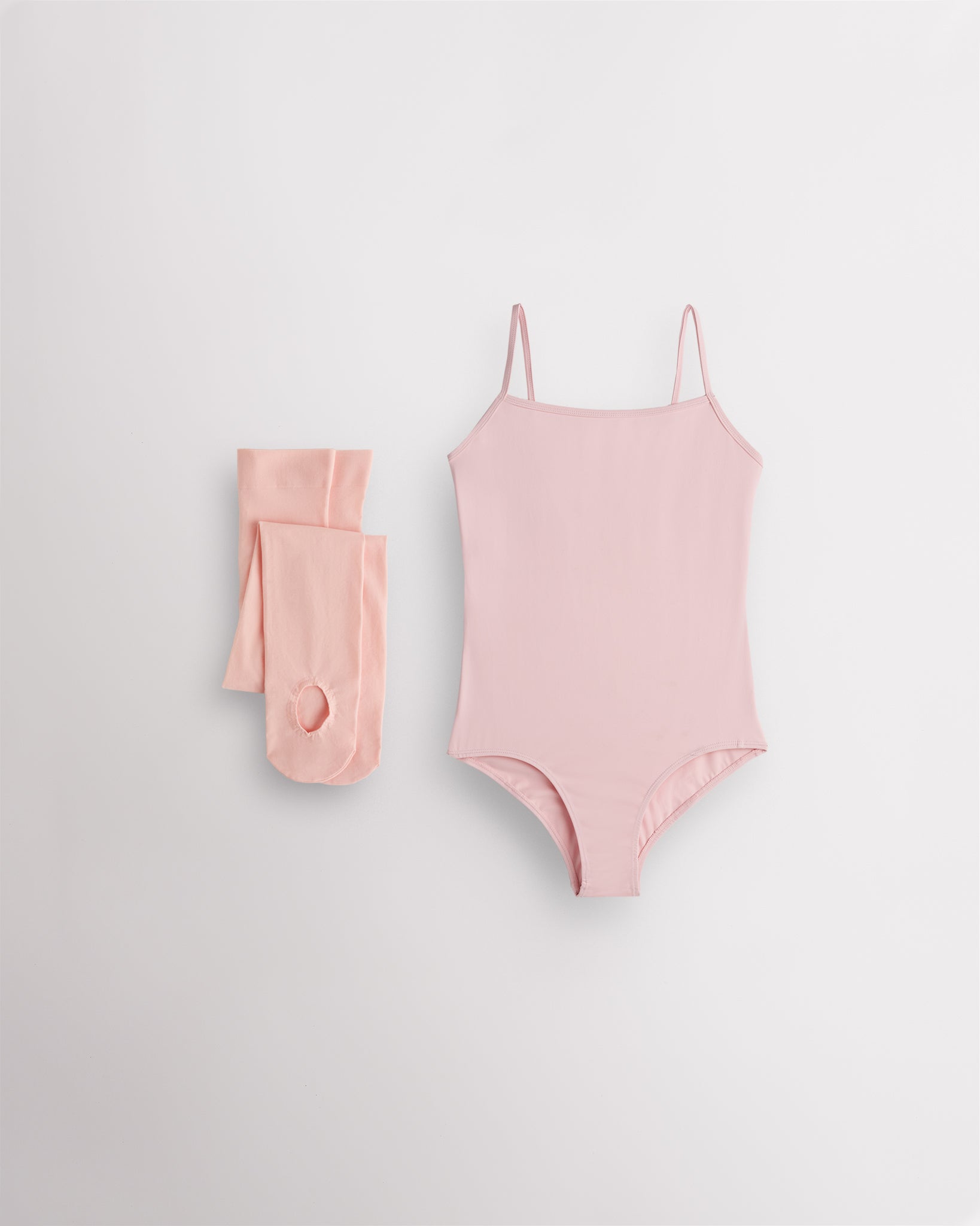 Ballet Pink girls camisole leotard with pink convertible dance tights laid flat for ballet and dance class.