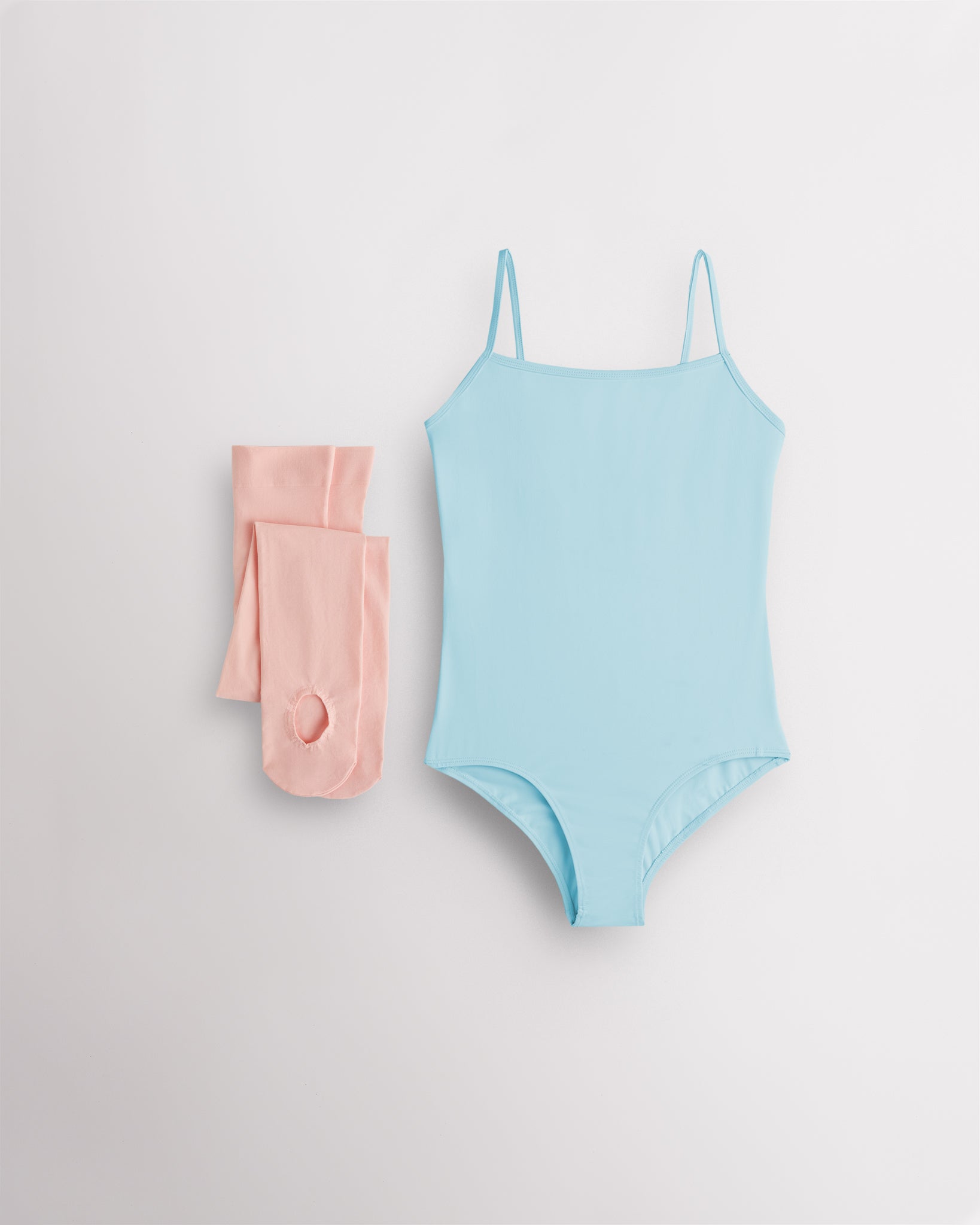Blue girls camisole leotard with pink convertible dance tights laid flat for ballet and dance class.