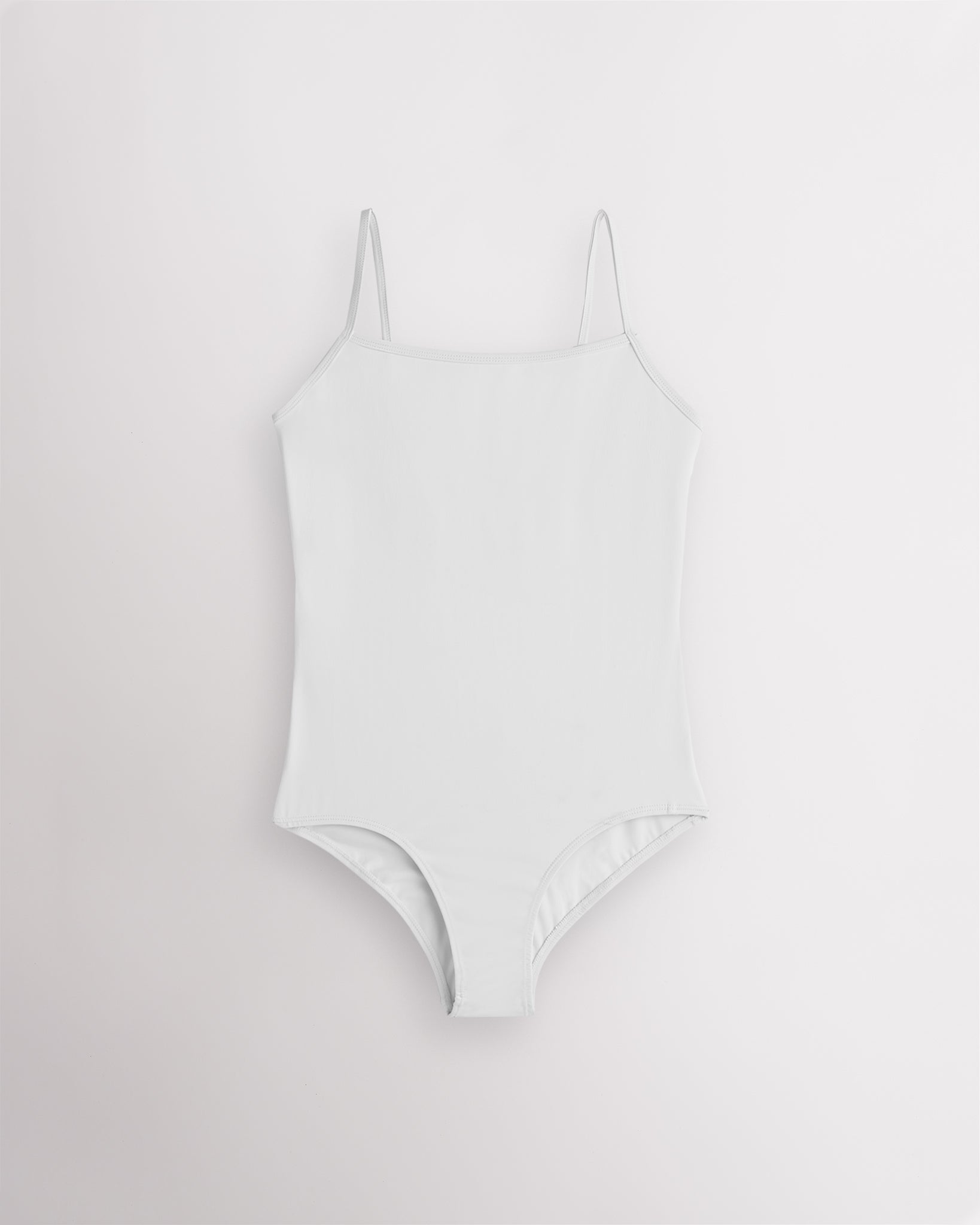 White girls camisole leotard with adjustable spaghetti straps, front lining, and smooth performance fabric.