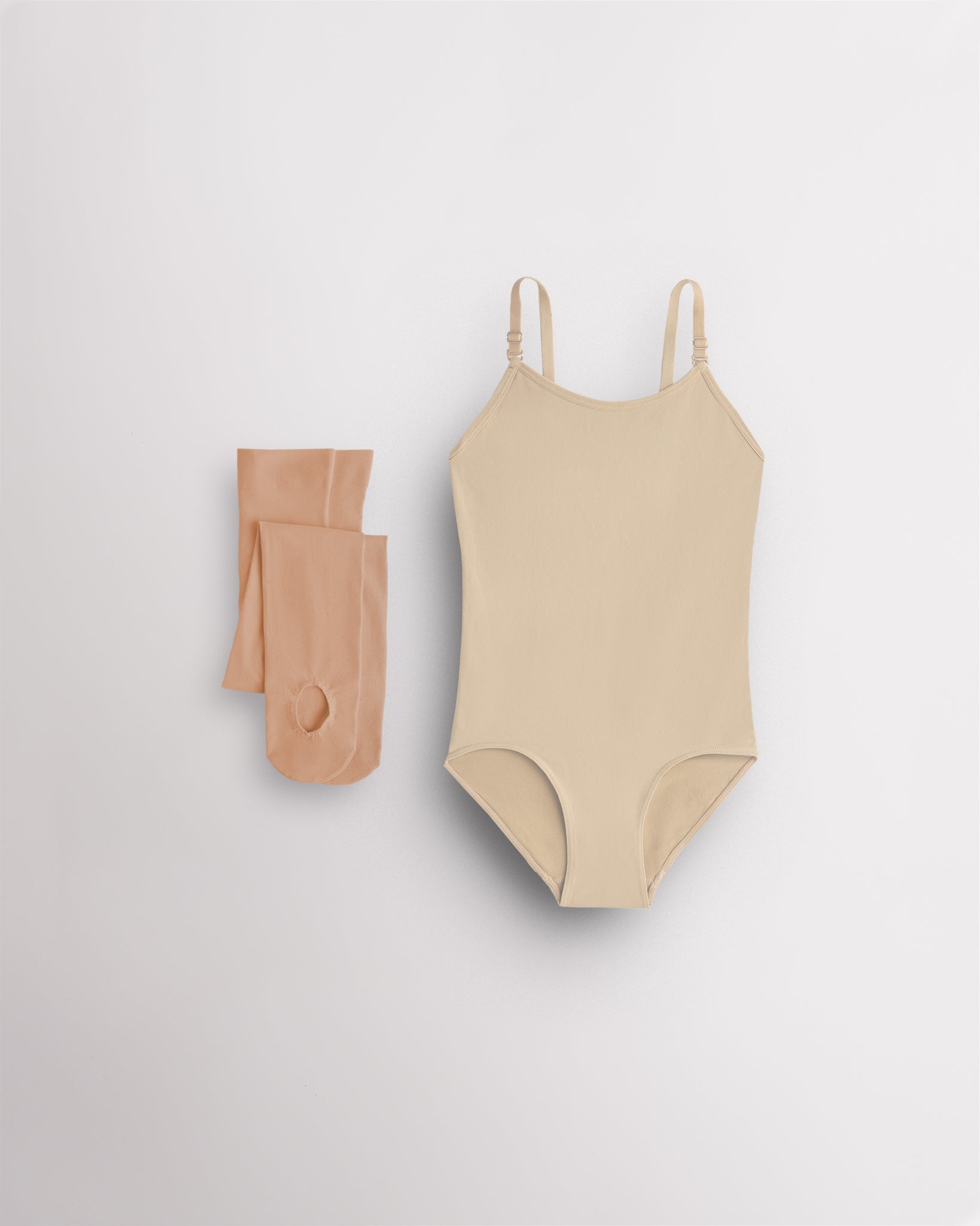 Light Nude camisole leotard for girls with tan convertible tights laid flat for ballet, dance, and costume layering.