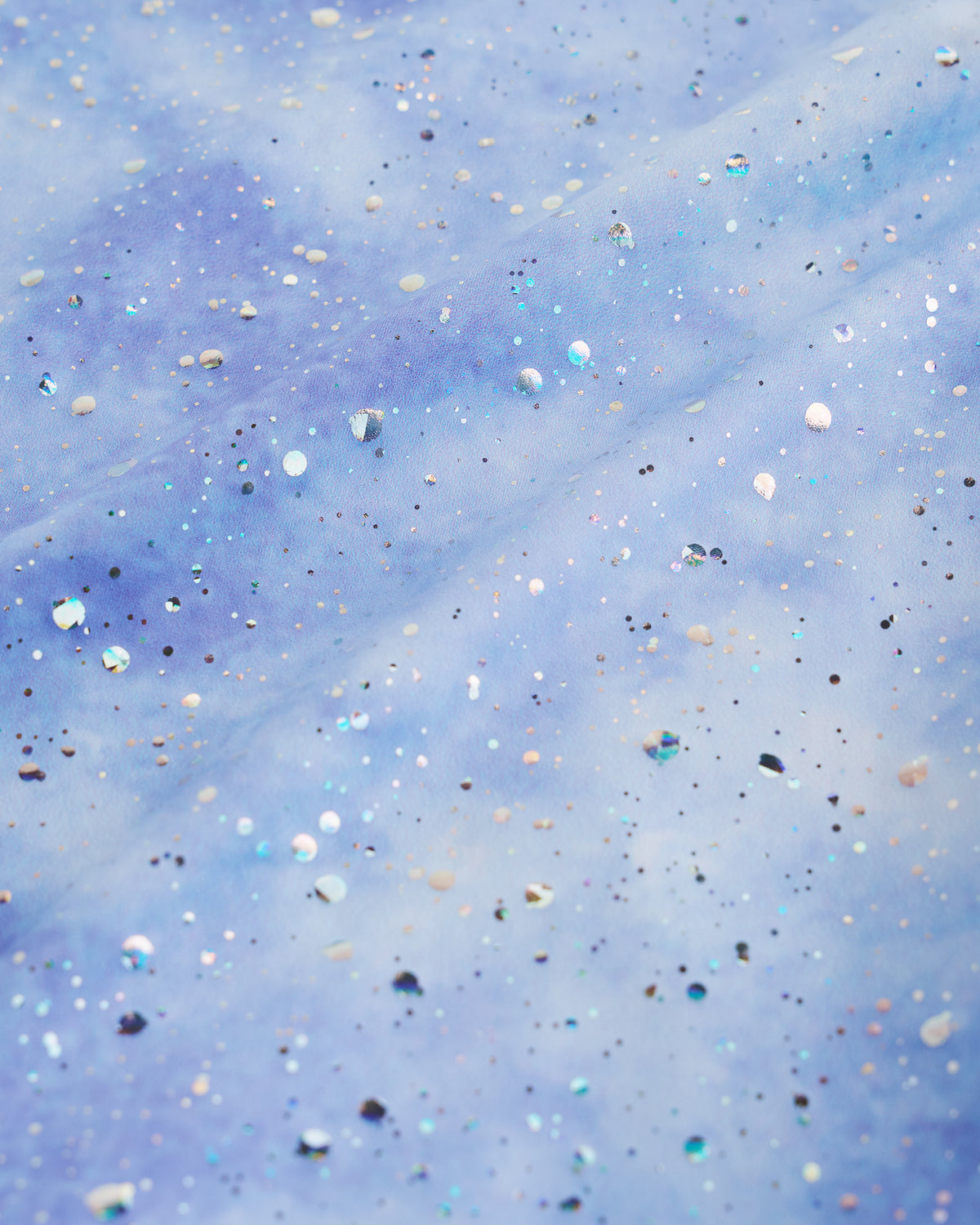 Close-up of Cloudburst Purple gymnastics unitard fabric showing the playful in-house print and shimmer details.
