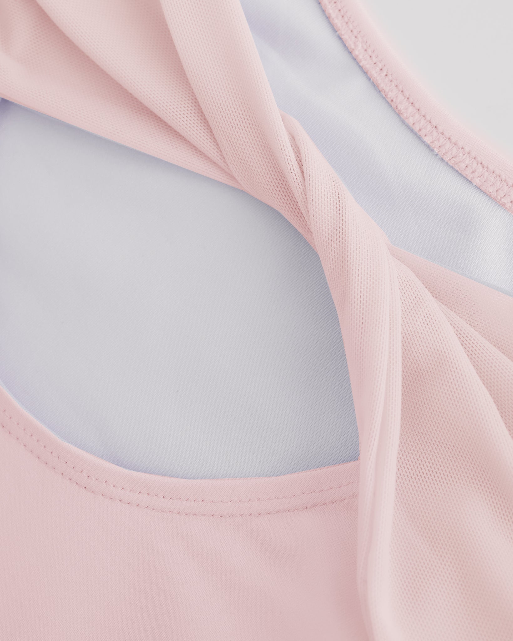 Close-up of Ballet Pink ballet leotard showing the sheer twisted mesh back fabric and smooth performance material.