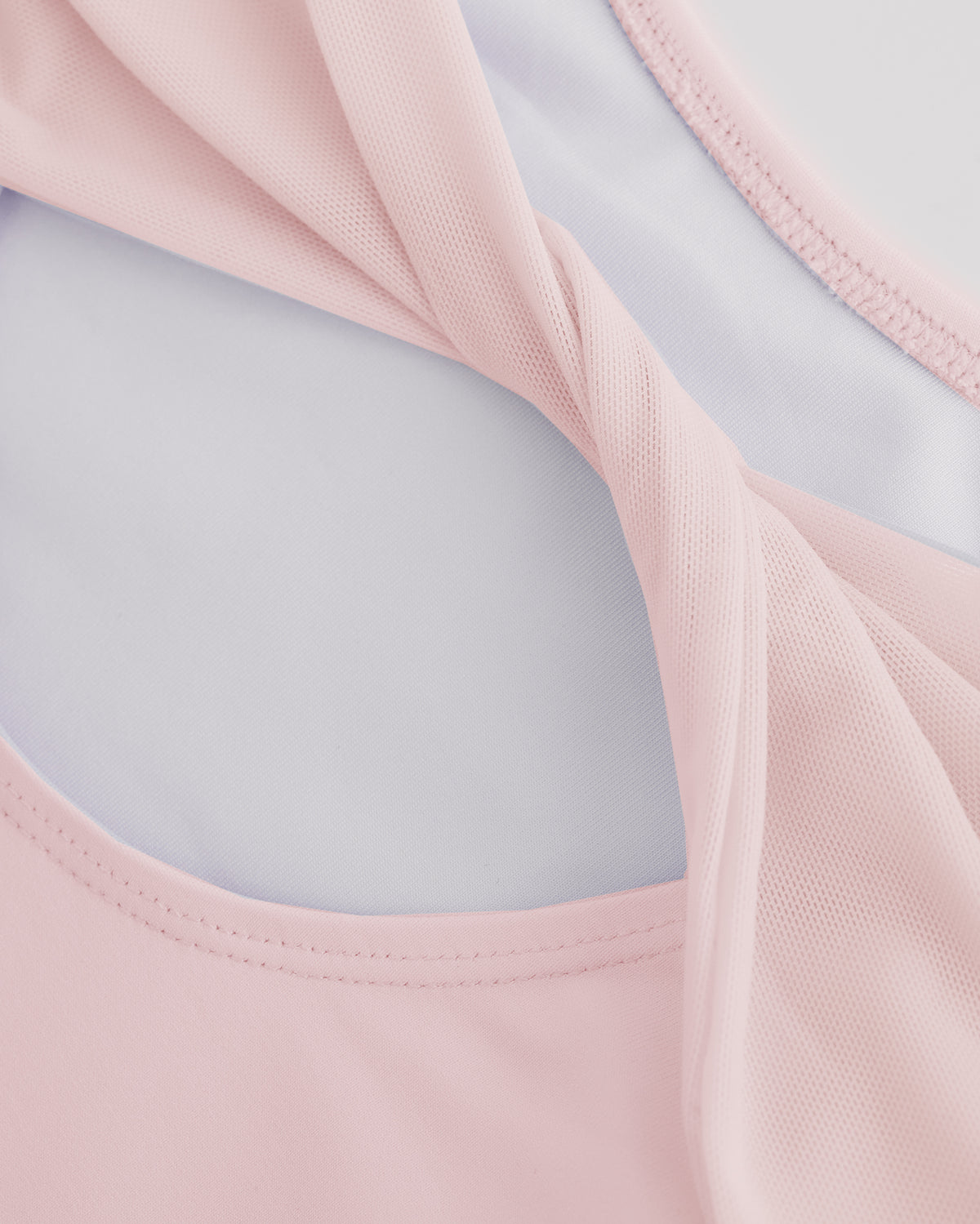 Close-up of Ballet Pink ballet leotard showing the sheer twisted mesh back fabric and smooth performance material.