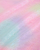 Close-up of Rainbow Mist girls unitard fabric showing butterflies, rainbows, moons, stars, and soft shimmer detail.