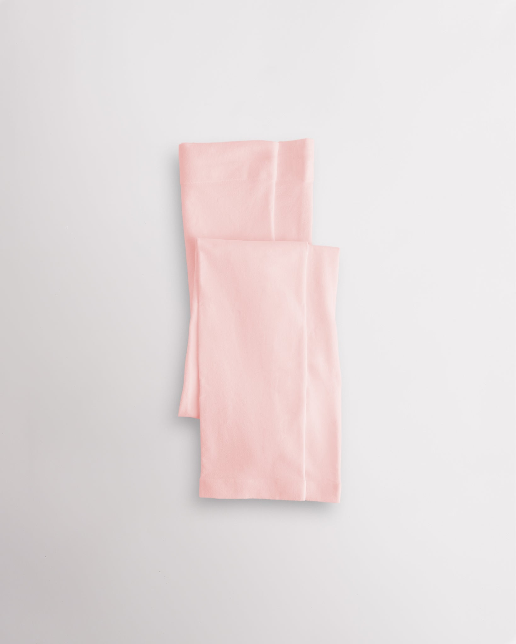 Pink girls microfiber footless dance tights folded flat with elastic waistband and soft fabric for ballet and dance practice.