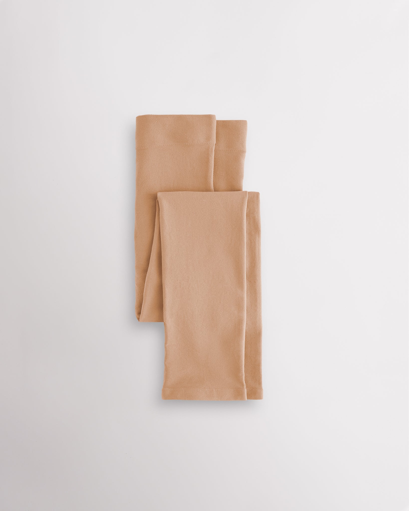 Light Tan girls microfiber footless dance tights folded flat with elastic waistband and soft fabric for ballet and dance practice.