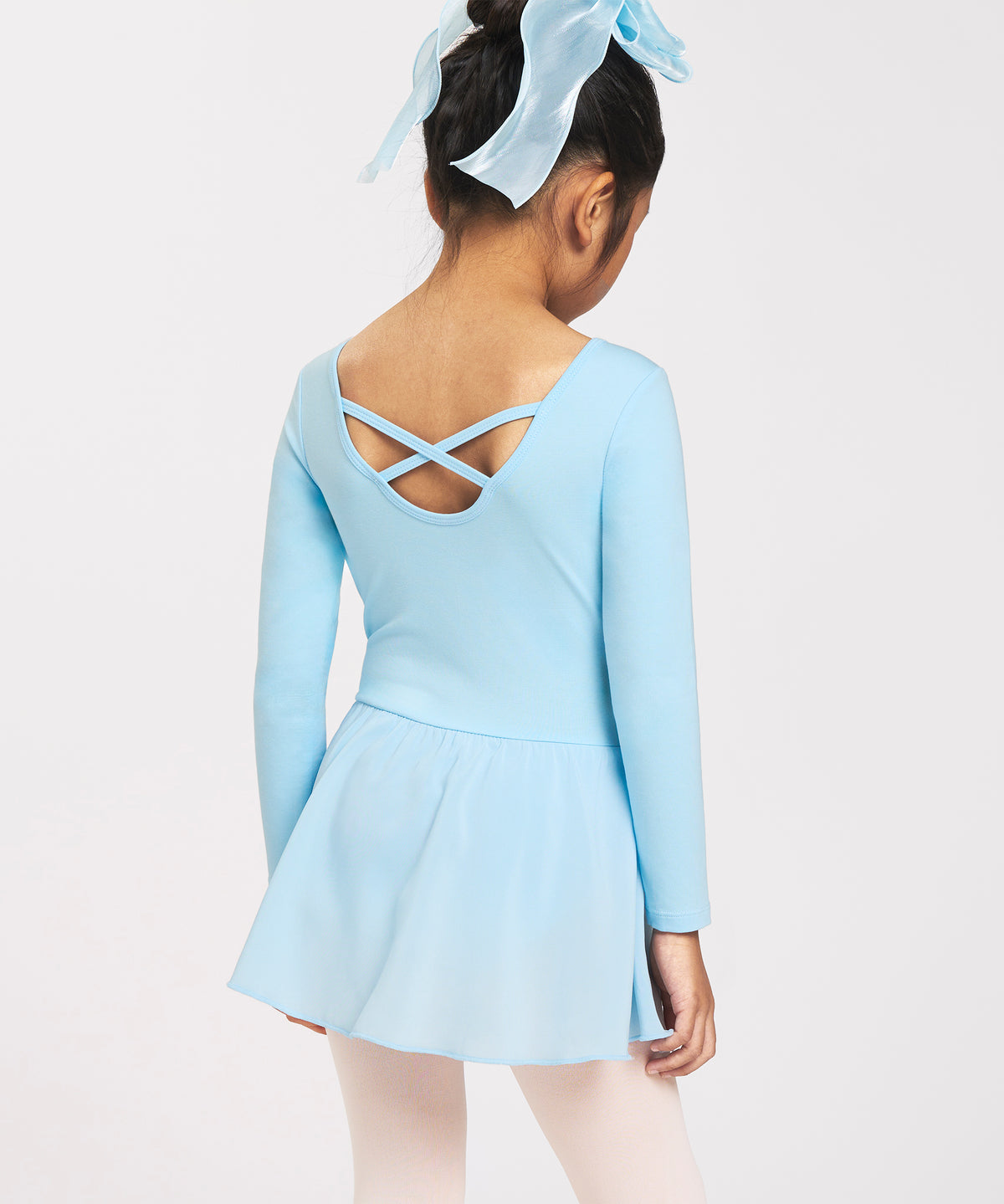 Back view of girl wearing a blue ballerina dress with long sleeves, crisscross back detail, chiffon skirt, and bow accent.