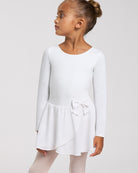 Girl wearing a white long sleeve ballet dress with crew neckline, attached chiffon wrap skirt, bow accent, and ballet tights.