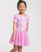 Girl wearing a Bow Dreams ballet dress with short sleeves, attached skirt, and colorful shimmering print.