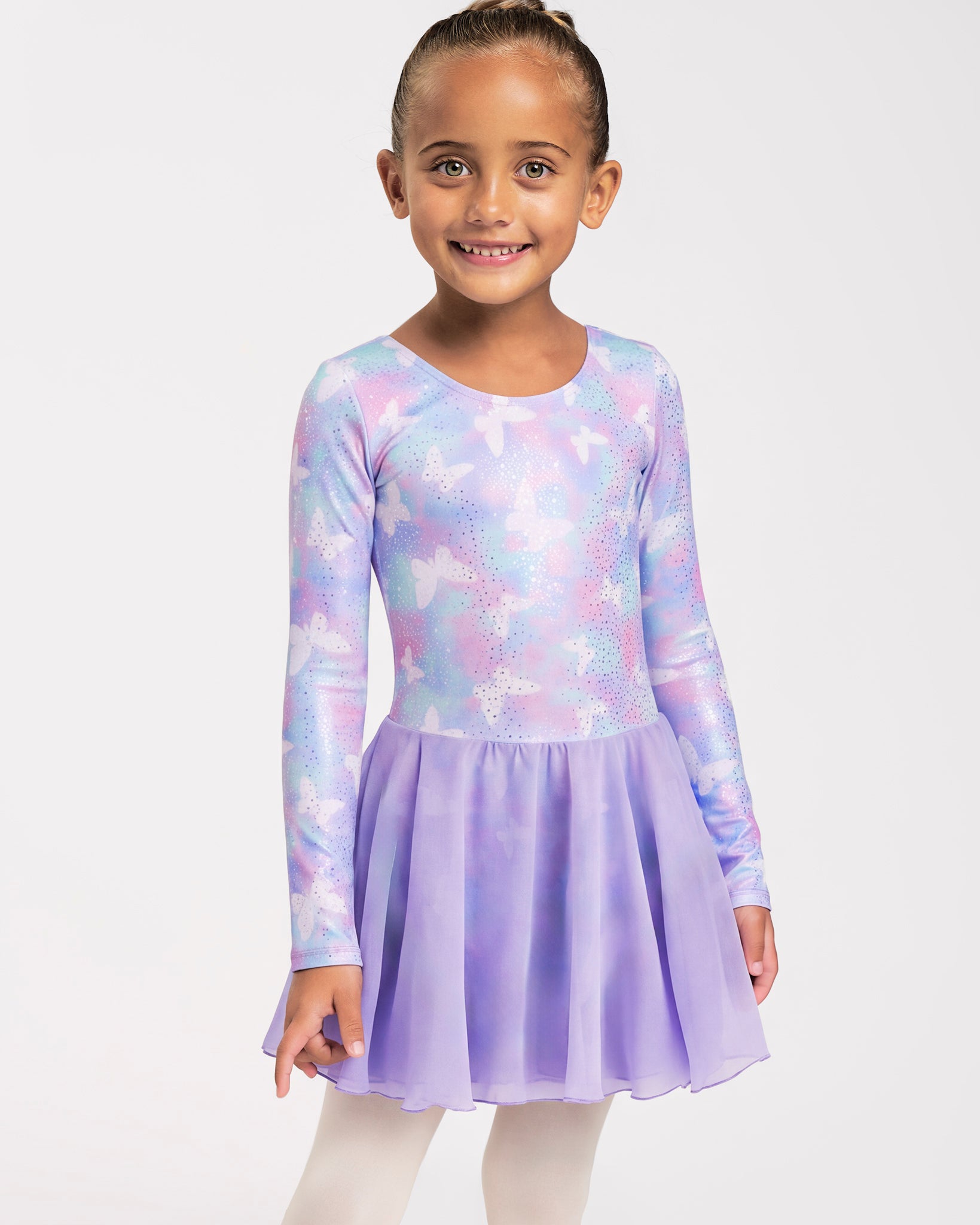 Girl wearing a Magic Flutter long sleeve ballet dress with attached skirt, shimmering print, and ballet tights.