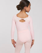 Back view of girl wearing a Ballet Pink leotard for girls with long sleeves, scoop back, and twisted mesh detail.