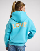 Back view of girl wearing an aqua blue puppy hoodie with relaxed oversized fit and large LOVE corgi graphic on the back.