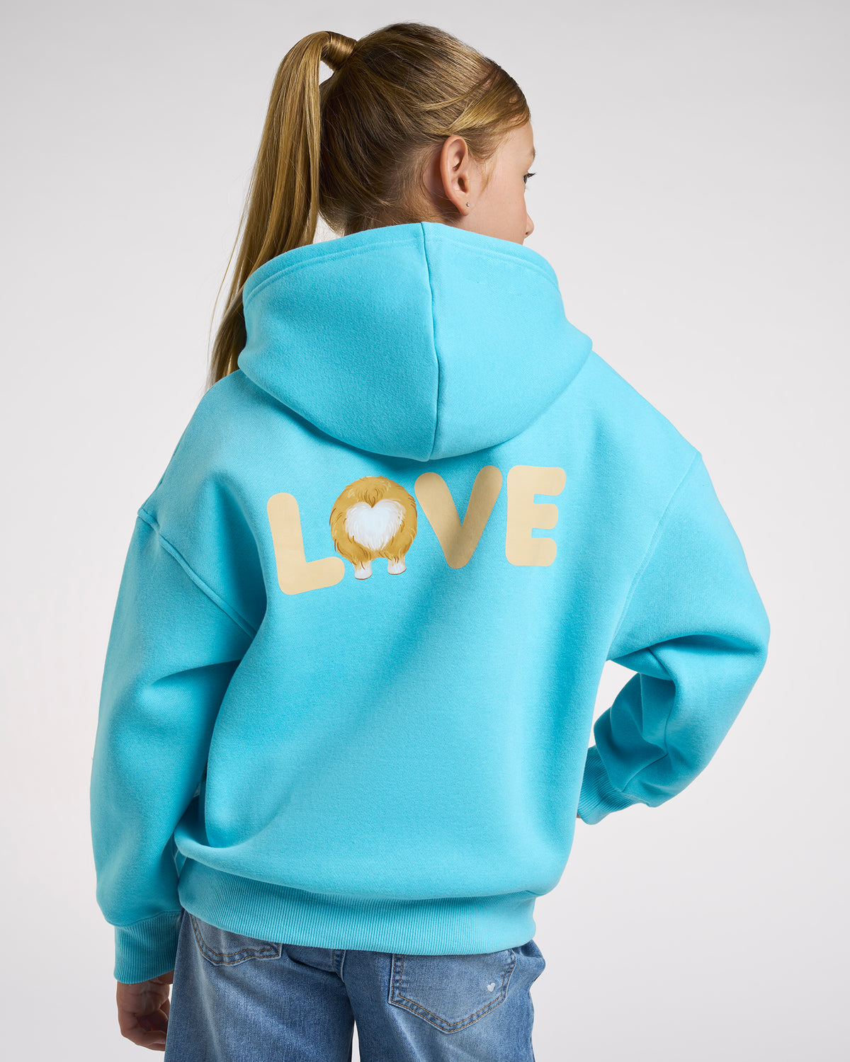 Back view of girl wearing an aqua blue puppy hoodie with relaxed oversized fit and large LOVE corgi graphic on the back.