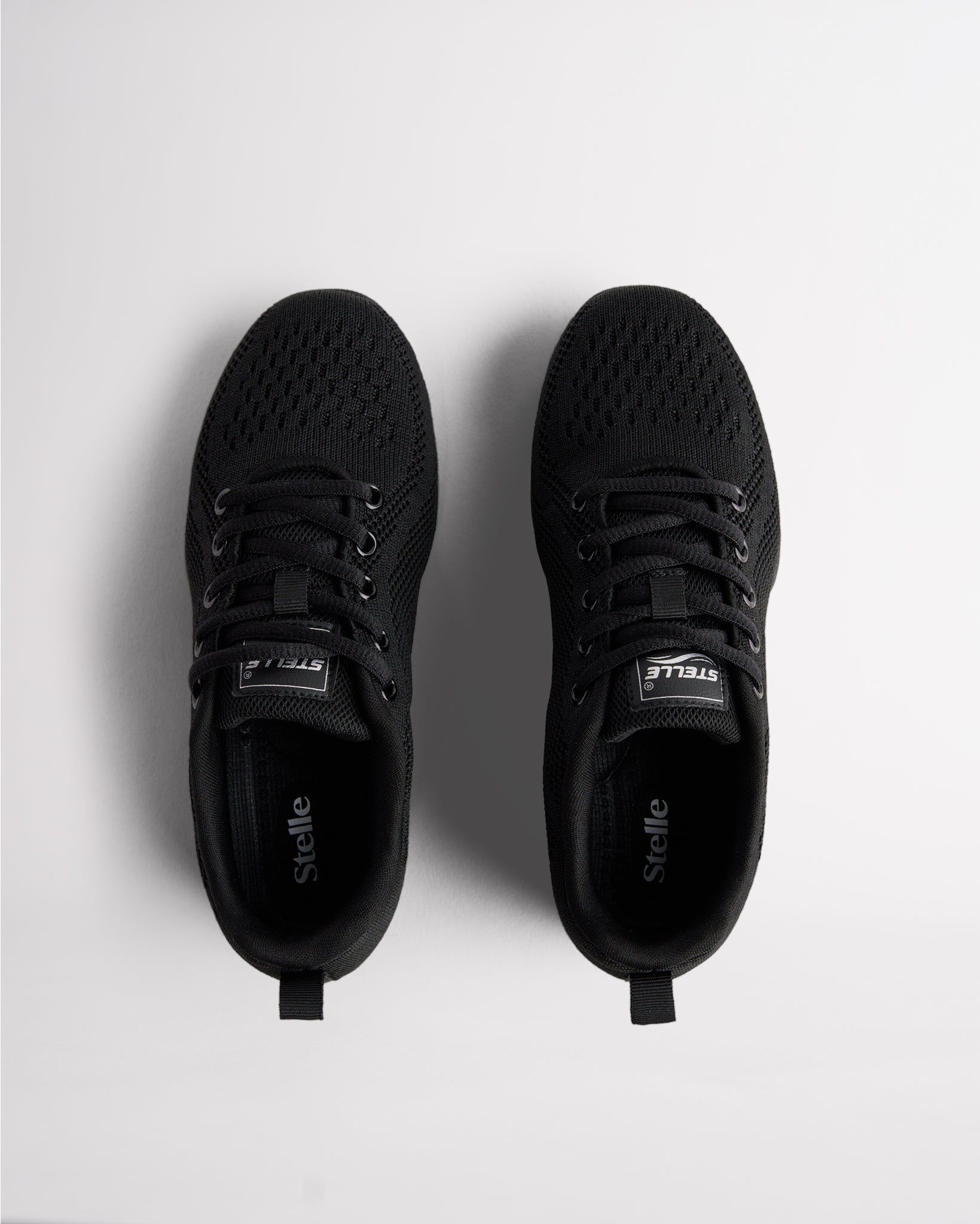 Top view of black lace-up cheer shoes with cushioned interior and Stelle branding