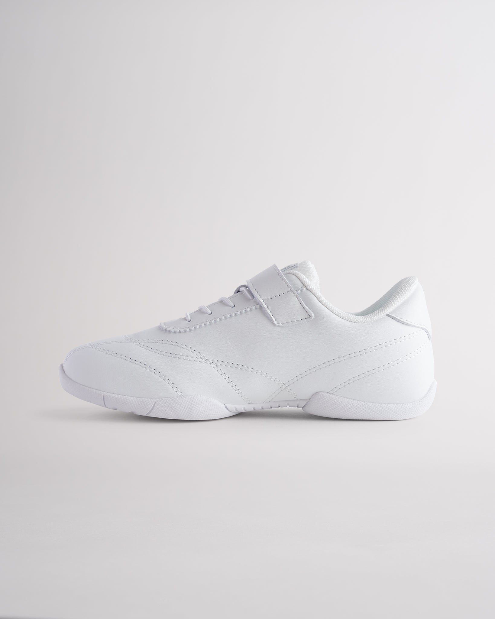 Kids white cheer shoes with Velcro closure and flexible sole for cheerleading and casual wear.