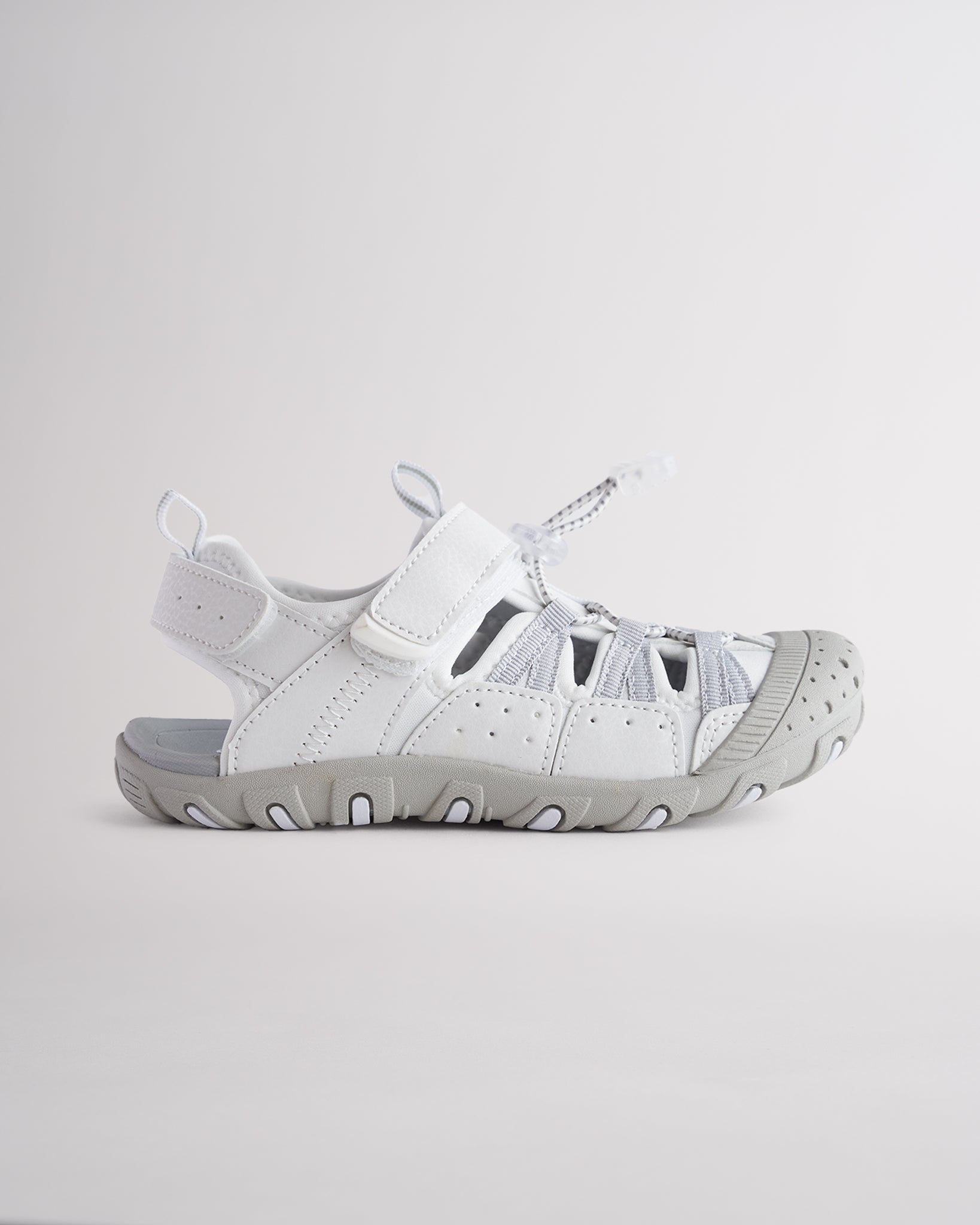 White kids sport sandal with closed-toe protection, cord lace system, and adjustable hook-and-loop strap