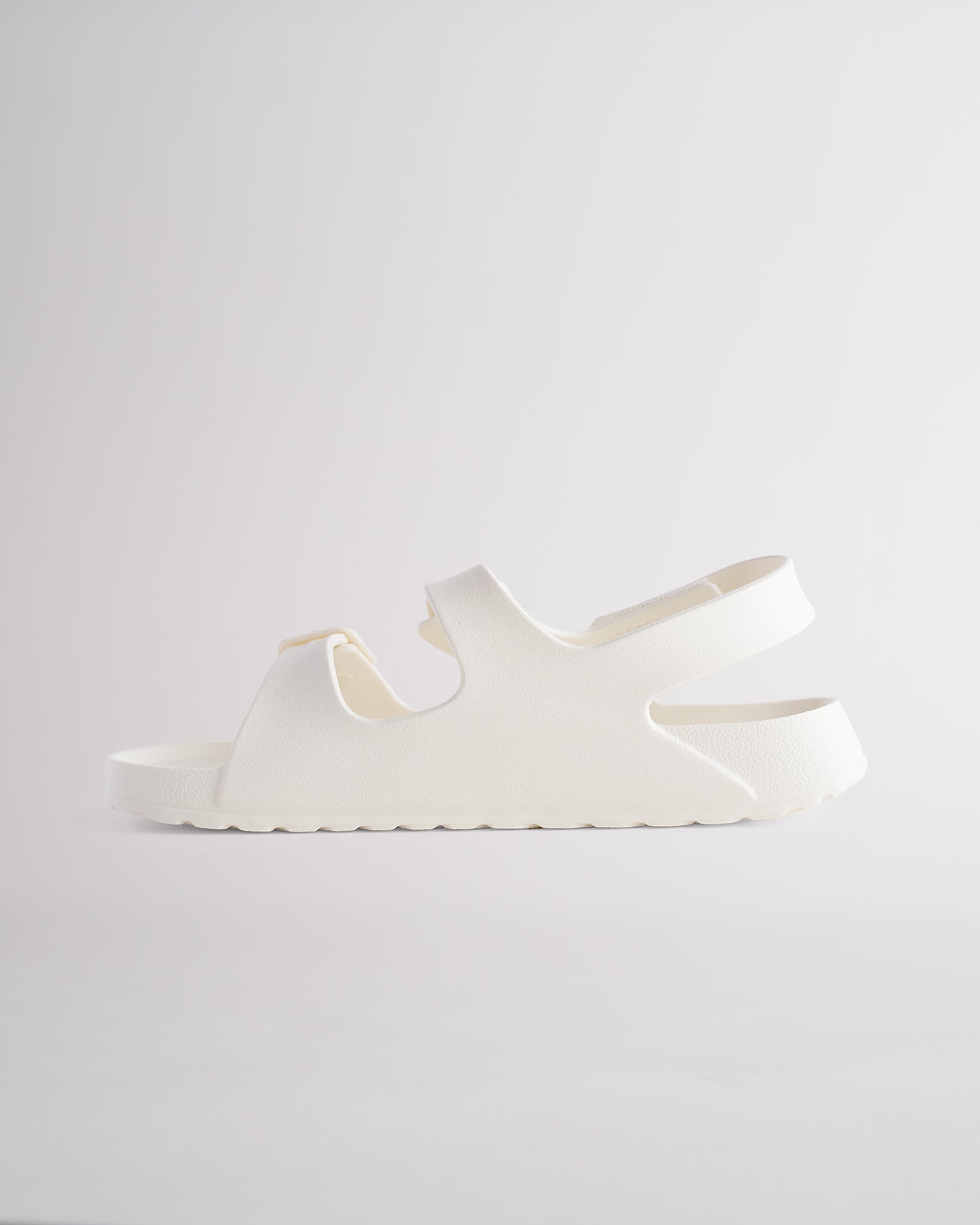 Creme sandals for kids featuring contoured footbed, flexible design, and secure back strap