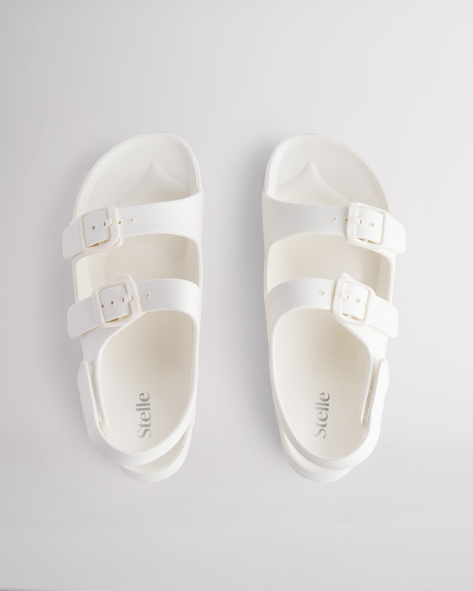 Top view of creme kids sandals with dual adjustable buckles, contoured footbed, and soft lightweight material