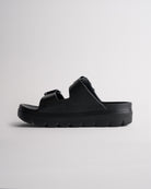 Side view of black Stelle Kids StelleCloud Buckled Slide showing the easy slide-on design, raised sole, and adjustable straps.