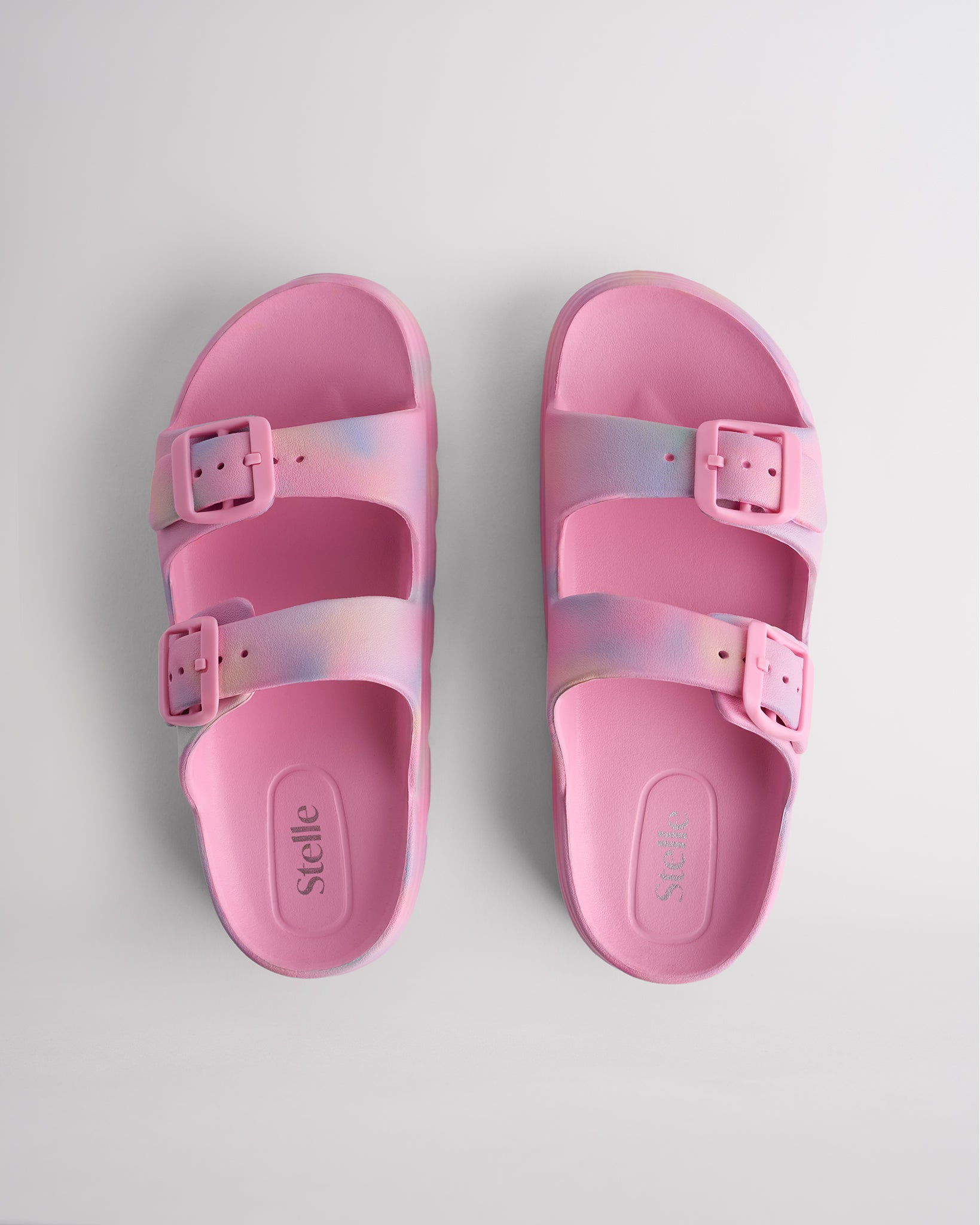 Top view of Cotton Candy Ombre Stelle Kids StelleCloud Buckled Slide with two buckle straps, contoured footbed, and Stelle logo detail.