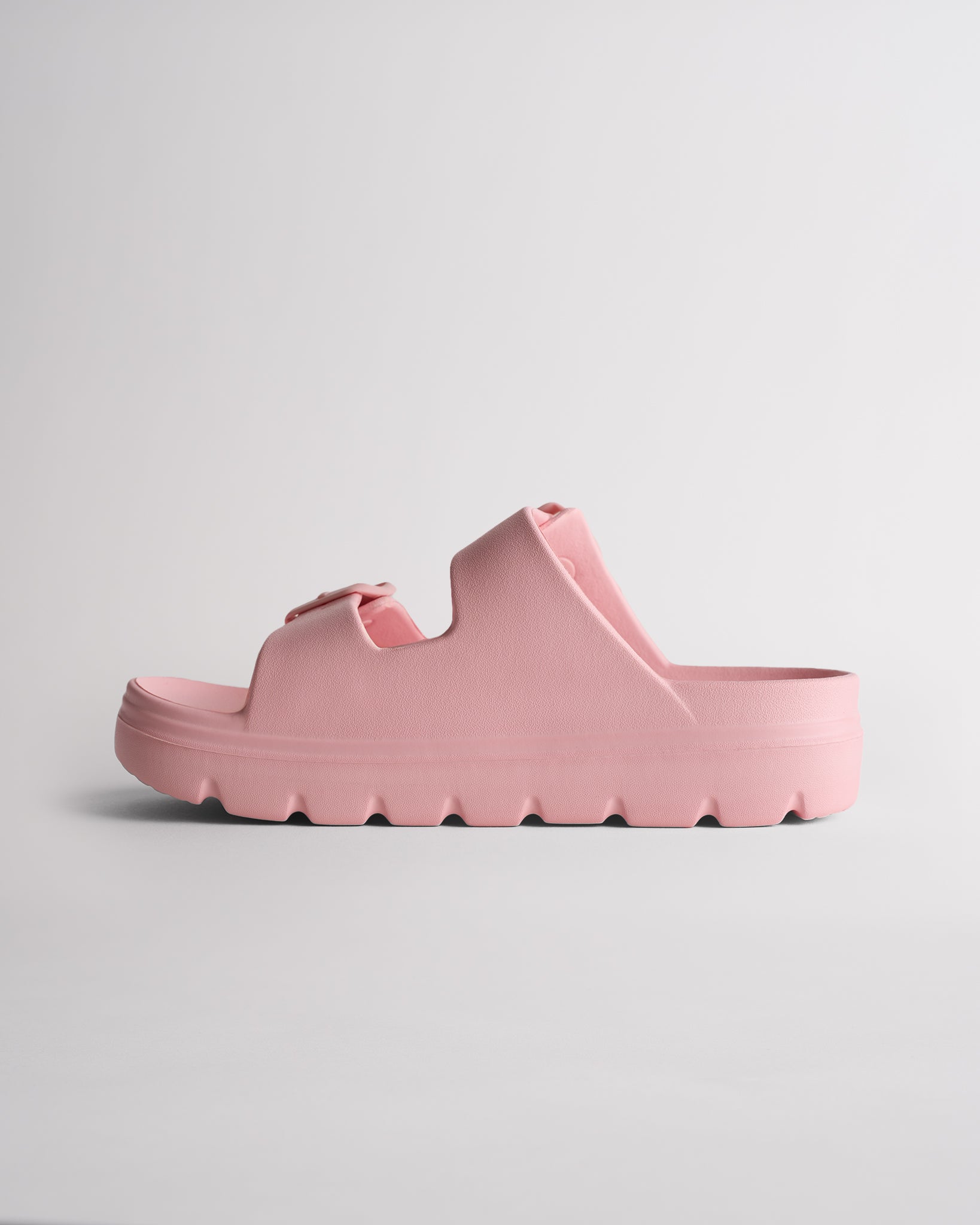 Side view of pink Stelle Kids StelleCloud Buckled Slide showing the easy slide-on design, raised sole, and adjustable straps.
