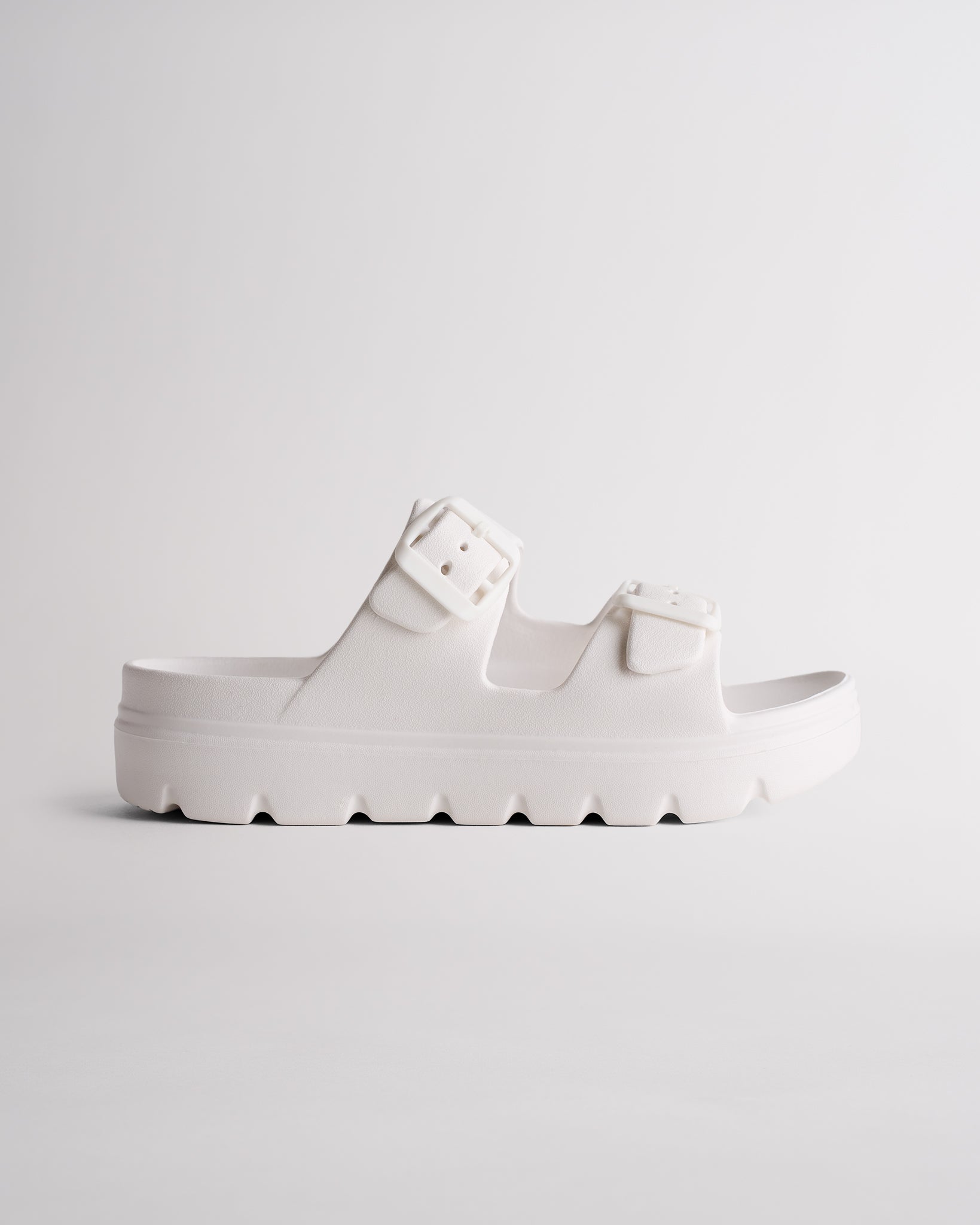 White Stelle Kids StelleCloud Buckled Slide with adjustable buckle straps, contoured footbed, and supportive casual design.