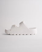 Side view of white Stelle Kids StelleCloud Buckled Slide showing the easy slide-on design, raised sole, and adjustable straps.