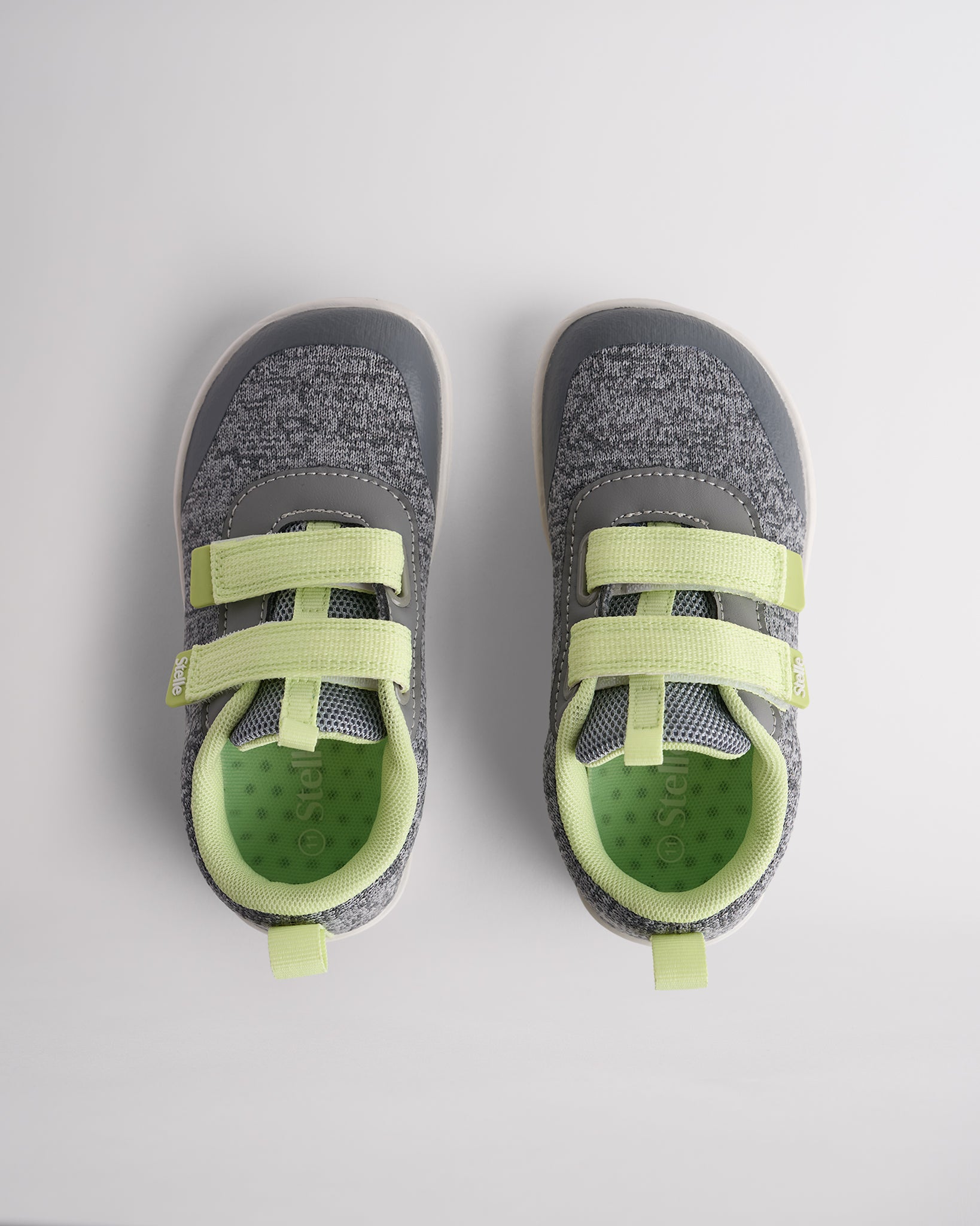 Top view of grey kids barefoot shoes showing dual straps and breathable interior