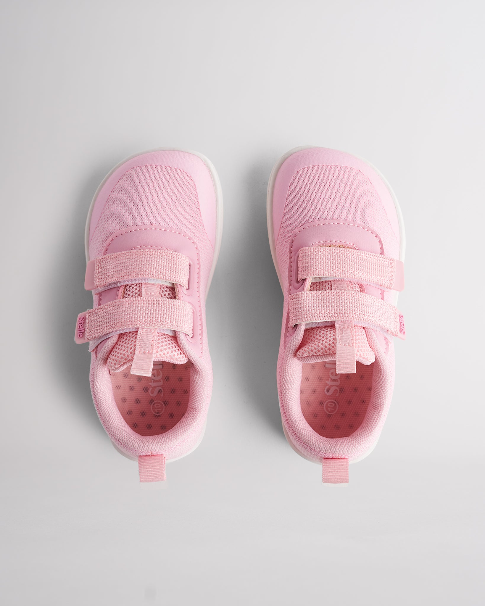 Top view of pink kids barefoot shoes showing dual straps and breathable interior