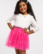 Girl wearing a white Peter Pan collar long sleeve top with lace trim, button placket, and pink sequin skirt.