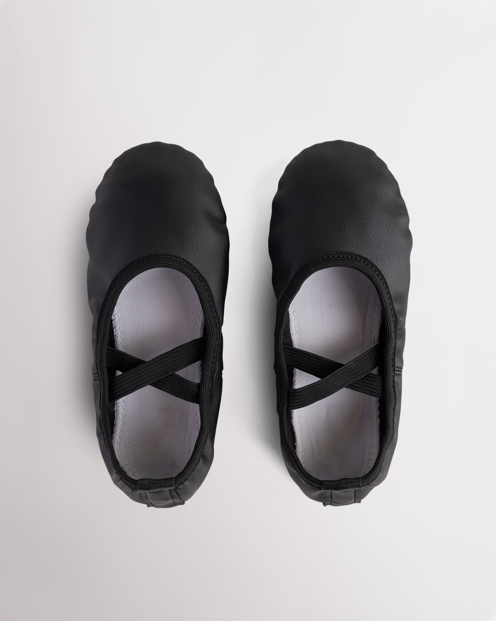 Pair of black kids vegan leather ballet shoes with cross elastic straps, soft lining, and easy-clean PU leather upper.