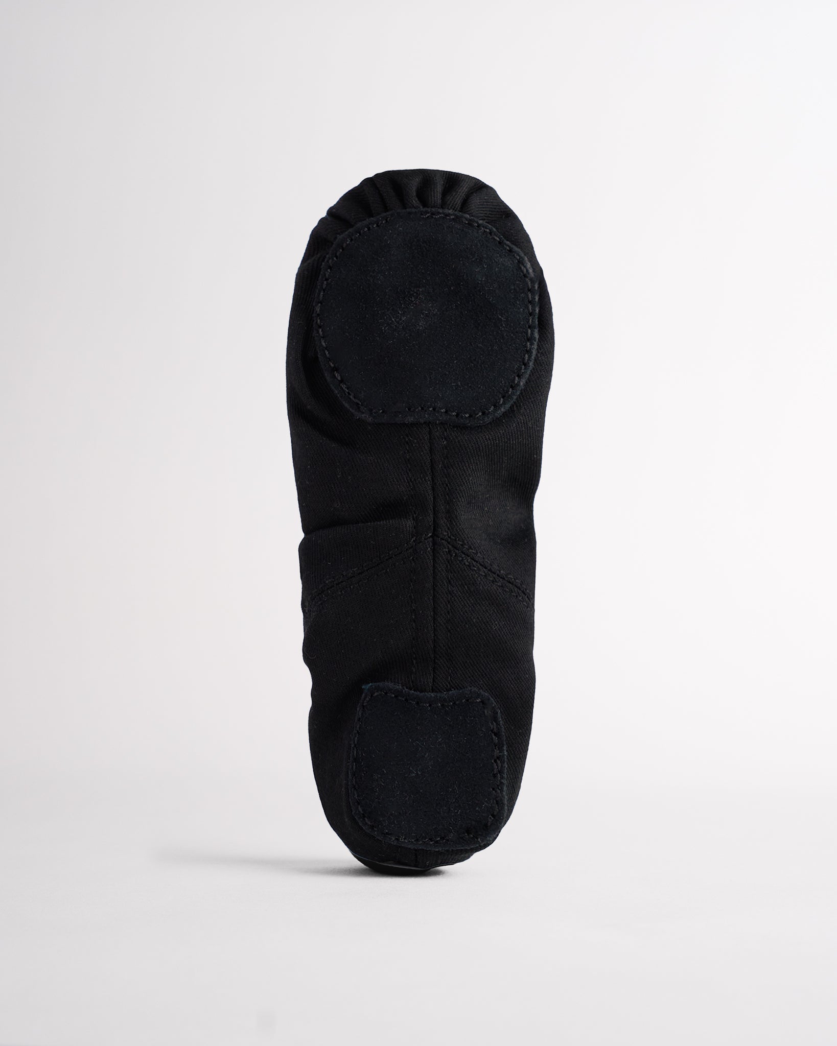 Sole view of black kids ballet shoe showing flexible suede split soles for easy movement and dance practice.