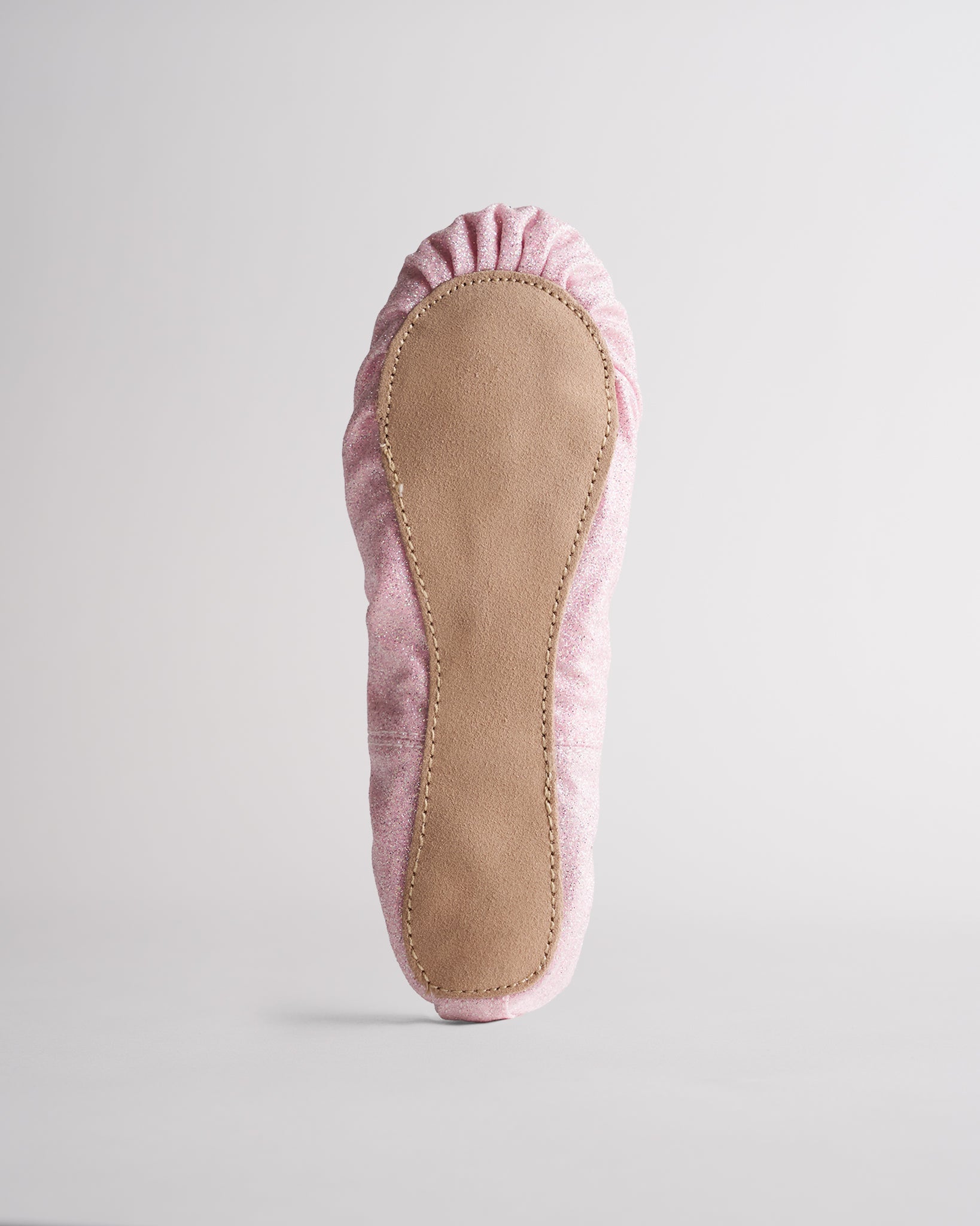 Kids dusty pink glitter ballet shoes with suede sole, bottom view