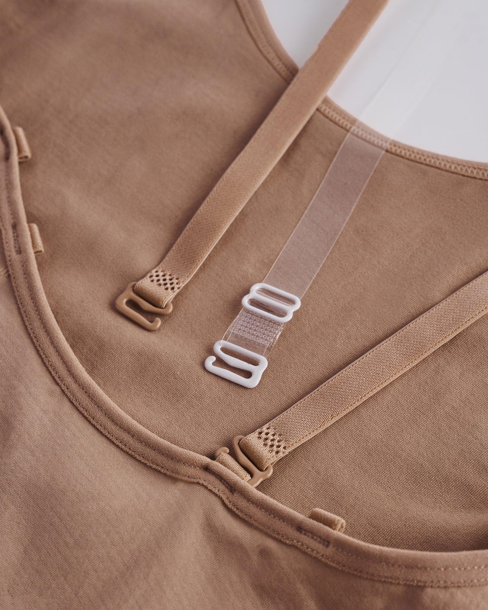 Close-up of Warm Tan girls camisole leotard showing adjustable multi-way straps and smooth stretch fabric for costume layering.