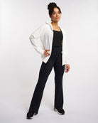 Woman styling white UV-protective jacket with black activewear for outdoor and athletic use.