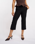 Close-up of black women’s high-rise capri pants with straight-leg fit and smooth pull-on waistband.