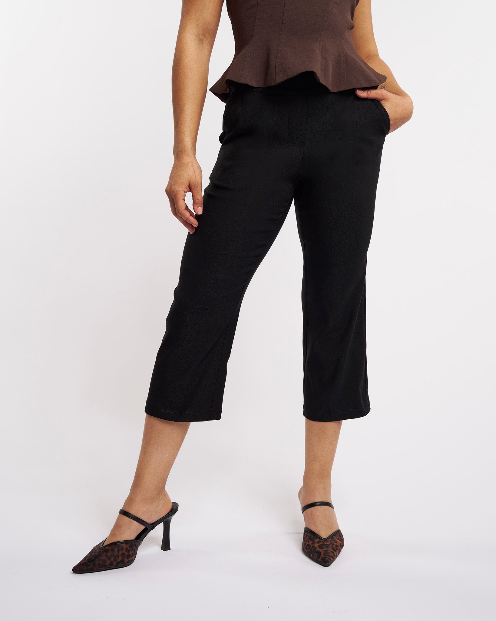 Close-up of black women’s high-rise capri pants with straight-leg fit and smooth pull-on waistband.